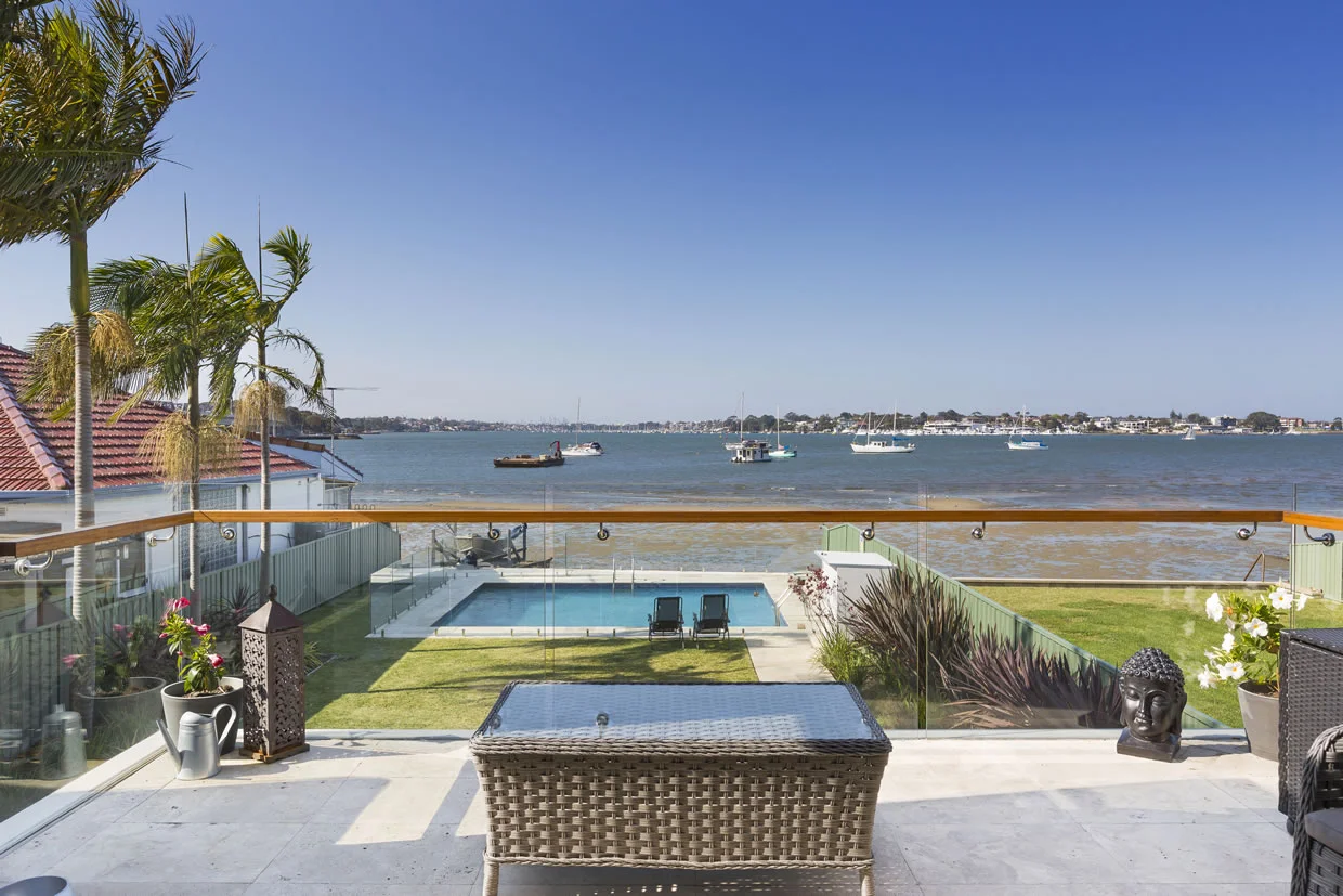 Backyard Balcony View To Pool And Water Horizon